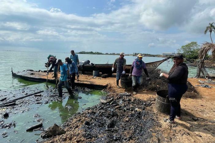 A work brigade sponsored by Venezuelan state-run oil company PDVSA, which critics blame for the oil spills, use shovels and rakes to remove congealed petroleum from a Lake Maracaibo beach.