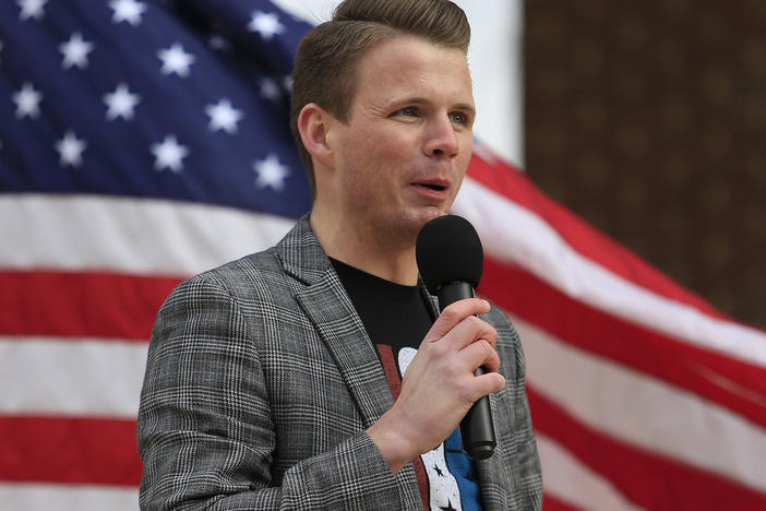 Ryan Fournier, pictured here speaking at a rally in Sugar Hill, Georgia in 2021, has been charged with assaulting a woman with a firearm.