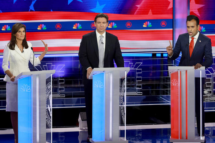 Republican presidential candidate former U.N. Ambassador Nikki Haley puts her hand up to Vivek Ramaswamy while he speaks to her as Florida Gov. Ron DeSantis (C) listens during the NBC News Republican Presidential Primary Debate.