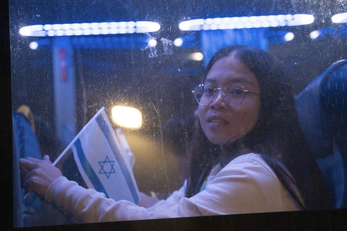 Thai nationals ride a bus as they leave Shamir hospital in Ramla, Israel, on Wednesday, on their way back to Thailand after being released from Hamas' custody.