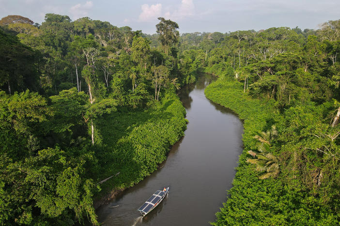 Achuar people ply the Rio Wichimi in a solar canoe. The nonprofit Kara Solar has helped fund a fleet of six sun-powered craft in hopes of benefitting the Indigenous Achuar while reducing pressure to build roads in the rainforest.