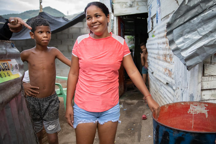 In La Paz, a low-income neighborhood on the outskirts of Santa Marta, Colombia, water service from the local utility can be erratic or nonexistent. Pictured: Neighborhood kids stand next to a rain barrel positioned under a corrugated roof.