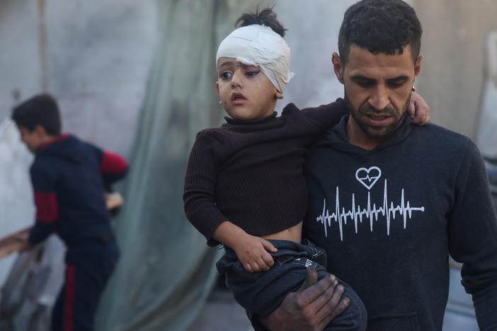 A Palestinian man carries a child wounded during an Israeli bombardment in Rafah, on the southern Gaza Strip, on Saturday.