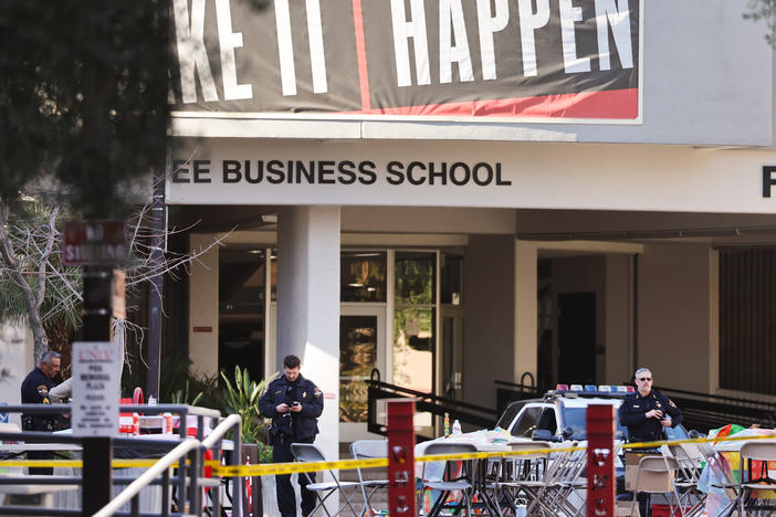 Police officers keep watch Thursday near the scene outside Frank and Estella Beam Hall, where the UNLV Lee Business School is located, the morning after a shooting left three dead at the University of Nevada, Las Vegas campus.