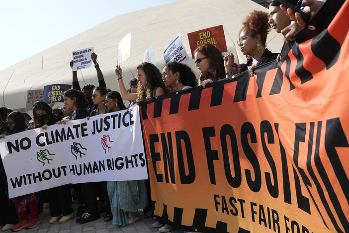 Demonstrators hold a sign reading "end fossil fuels" at the COP28 U.N. Climate Summit, Friday, Dec. 8, 2023, in Dubai, United Arab Emirates.