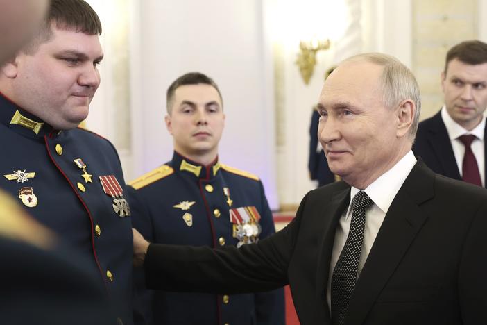 Russian President Vladimir Putin talks with awarded Russian servicemen at the Grand Kremlin Palace in Moscow on Friday.