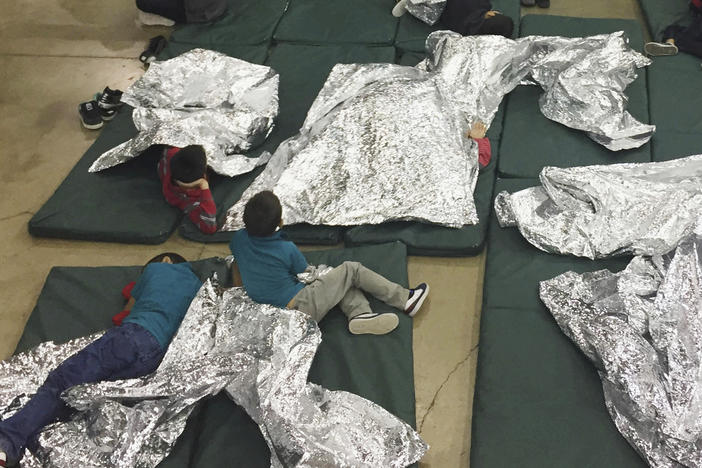 In this photo provided by U.S. Customs and Border Protection, people taken into custody related to cases of illegal entry into the U.S. waited in one of the cages at a facility in McAllen, Texas, in June 2018.