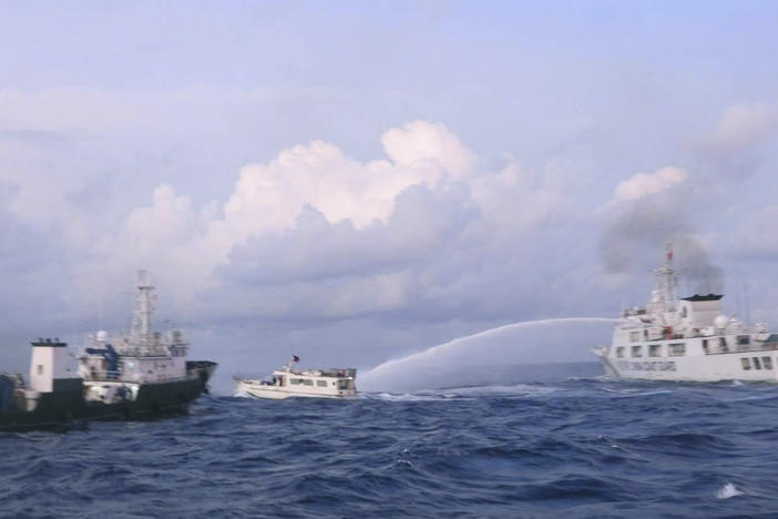 In this photo provided by the Philippine Coast Guard, a Chinese coast guard ship uses water cannons on Philippine navy-operated supply boat M/L Kalayaan as it approaches Second Thomas Shoal, locally known as Ayungin Shoal, in the disputed South China Sea on Sunday, Dec. 10, 2023.