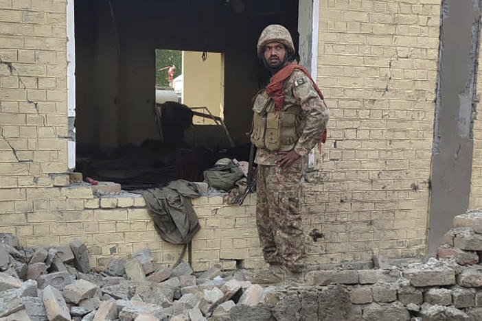 An army soldier examines damages on the site of a bombing at a police station on the outskirts of Dera Ismail Khan, Pakistan, Tuesday, Dec. 12, 2023.