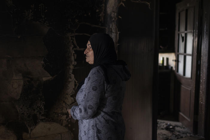 Widad Ghareeb visits a neighbor's house that was destroyed by an Israeli attack during fighting between Israel and Lebanese Hezbollah forces that escalated when the latest Gaza war began. Ghareeb's home next door was also heavily damaged.