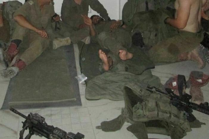 Alon Keren (left) and soldiers from his commando unit sleep on the floor of an evacuated Palestinian home in Gaza.