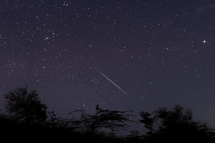 This photo taken late December 14, 2018 with a long time exposure shows a meteor streaking through the night sky over Myanmar during the Geminid meteor shower seen from Wundwin township near Mandalay city.