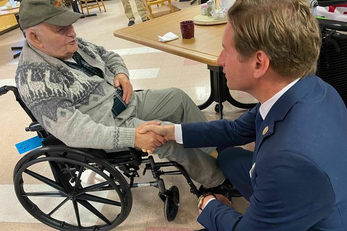 Stanley Piper talks with Rep. Dean Phillips, D-Minn., at the New Hampshire Veterans Home in Tilton, N.H. on Dec. 8, 2023.