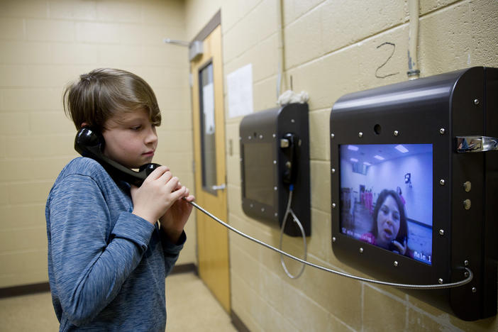 A boy uses a video screen to talk with his mother, who was held at the Campbell County Jail in Jacksboro, Tenn.