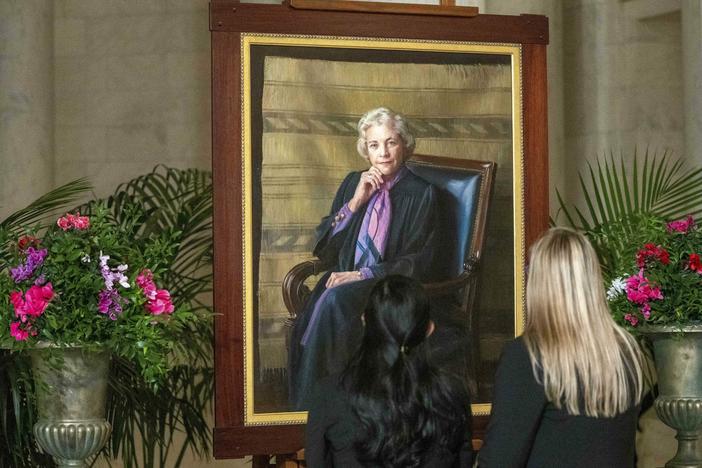 Mourners look at a portrait of O'Connor as her body lies in the Great Hall at the U.S.  Supreme Court on Monday.
