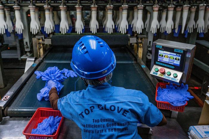 A worker inspects disposable gloves at a factory in Malaysia, a country that has been the top supplier of medical gloves to the U. S. and which is facing increasing competition from China.