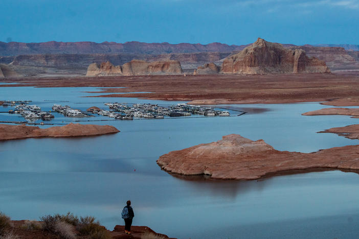 The Wahweap Marina, squeezed by the dropping and encroaching shoreline of Lake Powell on the Colorado River behind the Glen Canyon Dam outside Page, Ariz., on Feb. 20, 2023. The bathtub ring marking the once-high level of the lake is visible on the red rock formations in the distance. Full story <a href="https://www.cpr.org/2023/04/18/colorado-river-in-photos-parched/">here</a>.