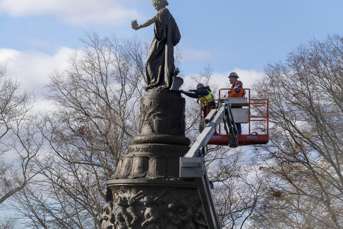 Workers prepare a Confederate memorial for removal in Arlington National Cemetery on Monday.