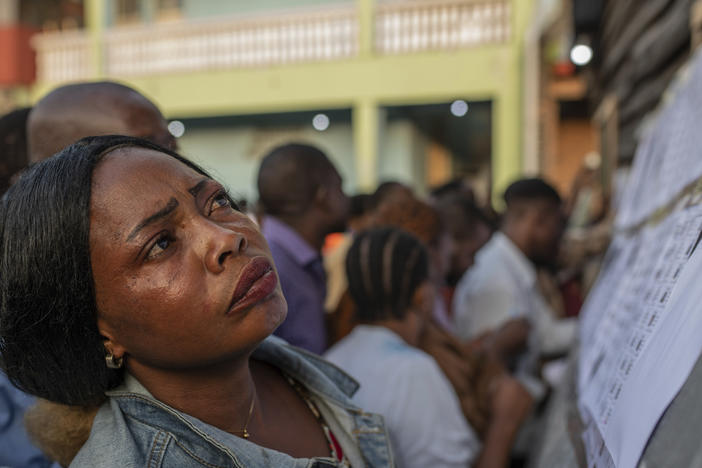 A woman looks for her name at a voting station in Goma, eastern Democratic Republic of the Congo, Wednesday, Dec. 20, 2023.