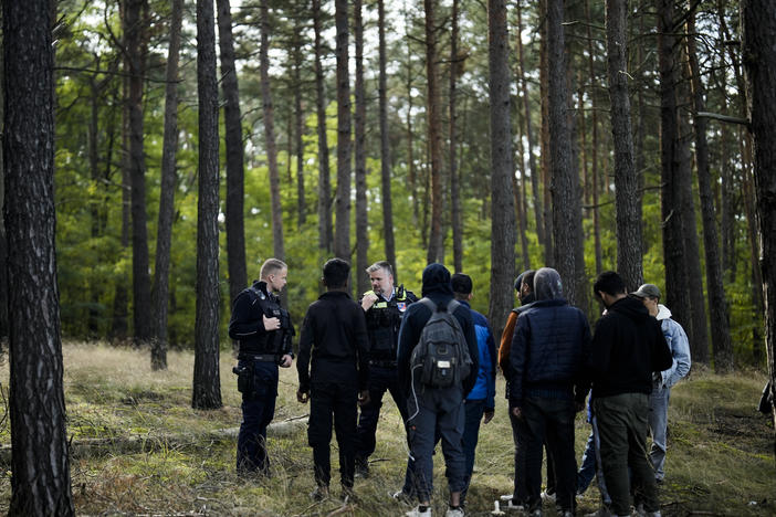 A Federal Police officer speaks into his radio as he and a colleague track down a group of migrants who illegally crossed the border from Poland into Germany, southeast of Berlin, Oct. 11. On Wednesday, European Union leaders hailed a major breakthrough in talks on new rules to control migration.