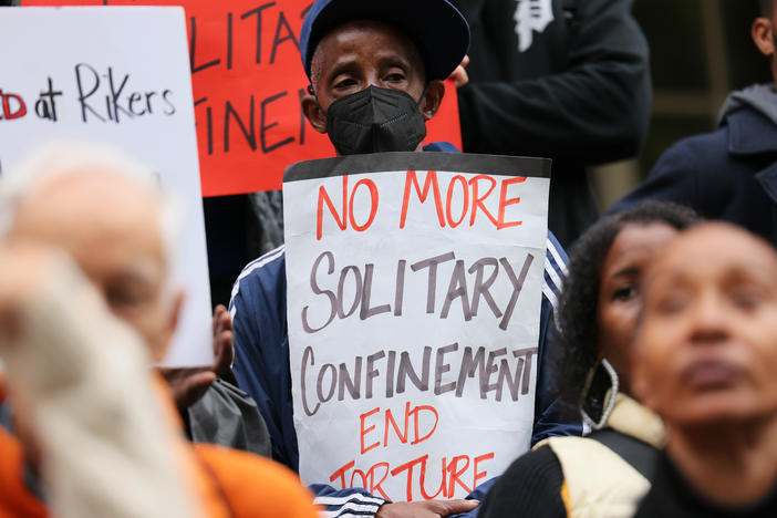People gather for a rally to protest conditions at New York City's Rikers Island jail in October of 2022. The New York City Council voted Wednesday to ban most uses of solitary confinement in the city's jails.