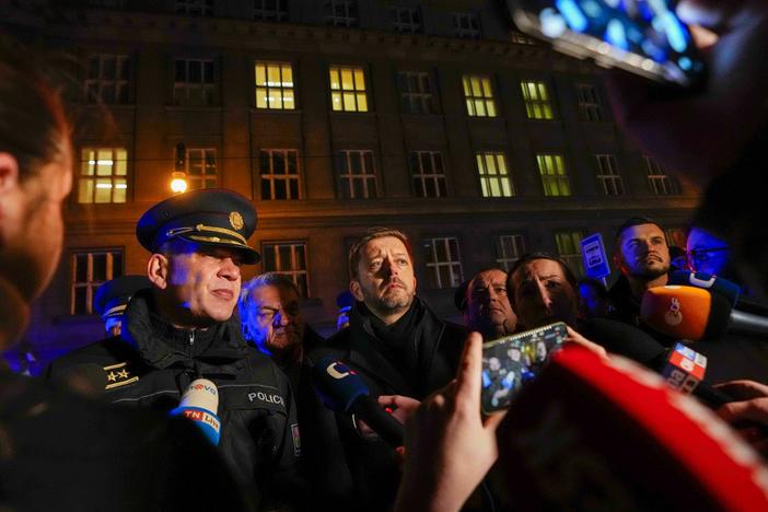 Czech Interior Minister Vit Rakusan (center) and Prague Police Chief Martin Vondrasek (left) speak to the media after a mass shooting in downtown Prague on Thursday.