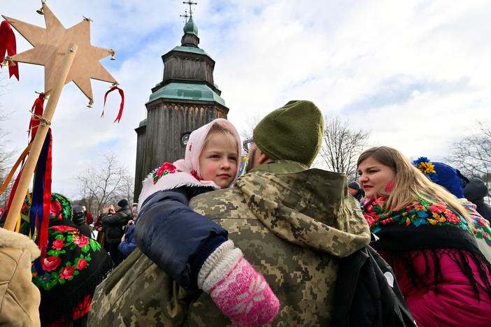 A Ukrainian serviceman holds his daughter as they take part in Christmas celebrations in the village of Pyrogove, near Kyiv on Monday.