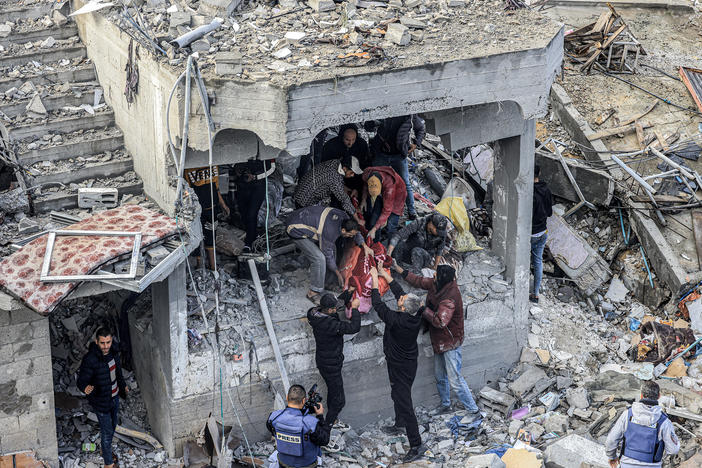 Men recover the body of a Palestinian killed in the aftermath of an overnight Israeli strike at al-Maghazi refugee camp in Gaza on Monday, as the war between Israel and Hamas carries on.