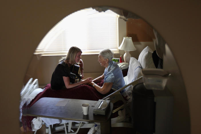 Terminally ill hospice resident Evelyn Breuning, 91, right, sits with music therapist Jen Dunlap in her bed in August 2009 in Lakewood, Colo. The nonprofit hospice, the second oldest in the United States, accepts the terminally ill regardless of their ability to pay, although most residents are covered by Medicare.