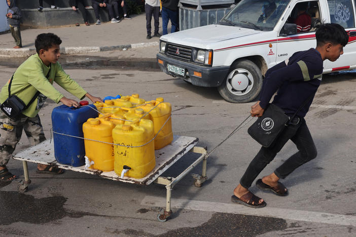 Internally displaced Palestinian children use a makeshift wheeled cart to haul water in Rafah in the southern Gaza Strip on Sunday, as battles continue between Israel and the militant group Hamas.