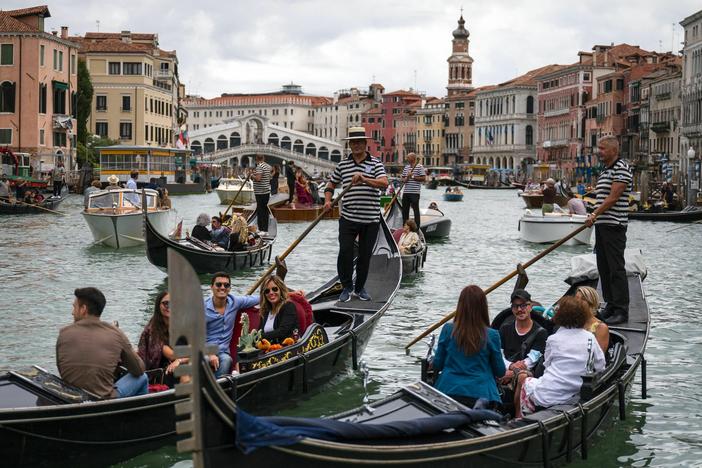 Tourists enjoy a gondola ride on the Grand Canal by the Rialto bridge in Venice in 2021.