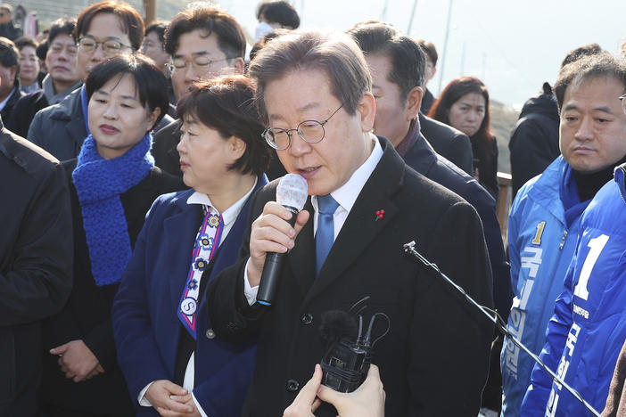 South Korean opposition leader Lee Jae-myung, center, speaks as he visits the construction site of a new airport in Busan, South Korea, Tuesday, Jan. 2, 2024. Lee was attacked and injured by an unidentified man during a visit Tuesday to the southeastern city of Busan, emergency officials said.