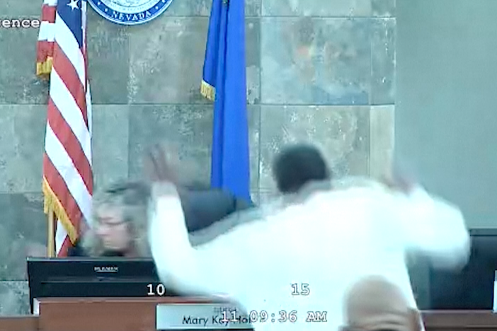 A defendant identified by court officials and records as Deobra Redden is seen about to leap over the desk of Judge Mary Kay Holthus during his sentencing in a felony battery case on Wednesday in Las Vegas. Authorities say the judge suffered minor injuries while a courtroom marshal suffered a bleeding gash on his forehead and a dislocated shoulder.