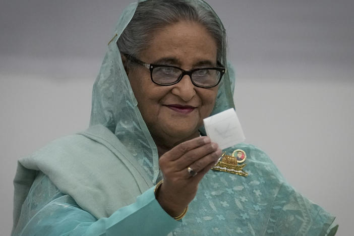 Bangladesh Prime Minister Sheikh Hasina shows her ballot paper as she casts her vote in Dhaka, Bangladesh, Sunday, Jan. 7, 2024. Polls have opened in Bangladesh as voters began casting their ballots in an election fraught with violence and a boycott from the main opposition party.