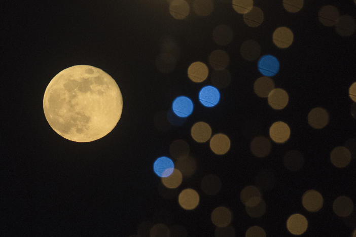 This photograph taken on December 27, 2023, shows the last full moon of the year, also known as the "Cold Moon," behind New Year's decorations in Skopje, the capital of the Republic of Macedonia.