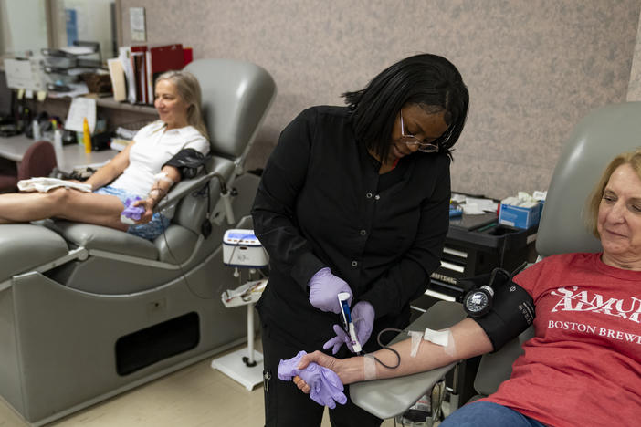 Tuyishimire Primitiva, phlebotomist with the American Red Cross, draws whole blood from Teresa McLeland at the American Red Cross on April 12, 2023, in Louisville, Ky.
