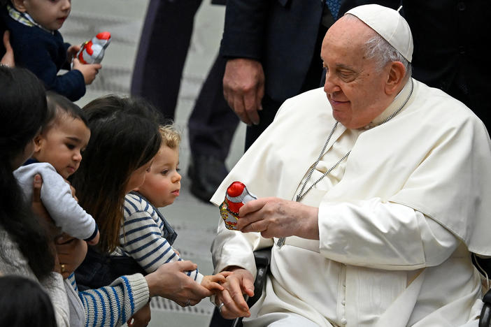 Pope Francis distributes sweets to children during the weekly general audience in Paul VI hall at the Vatican on Jan. 3.