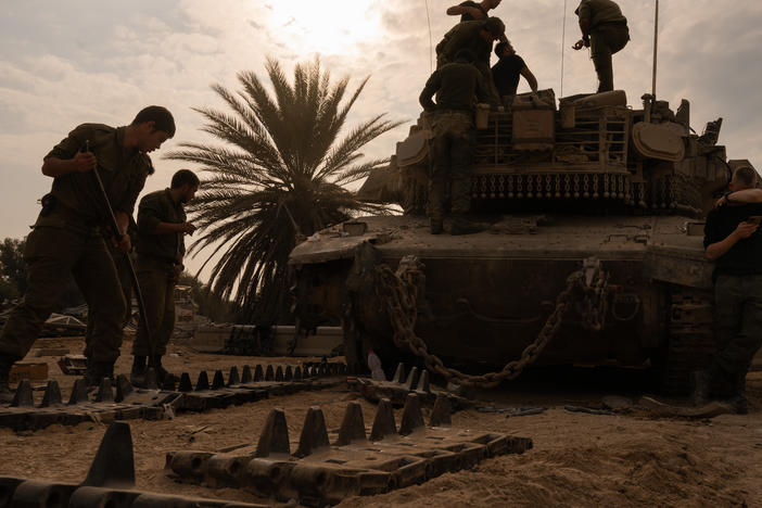 Israeli soldiers work on artillery after coming out of Gaza and across the border into Israel on Dec. 28, 2023.