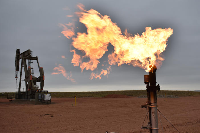 A flare burns natural gas at an oil well on Aug. 26, 2021, in Watford City, N.D. Oil and natural gas companies would have to pay a fee for methane emissions that exceed certain levels under a new rule proposed by the Biden administration.