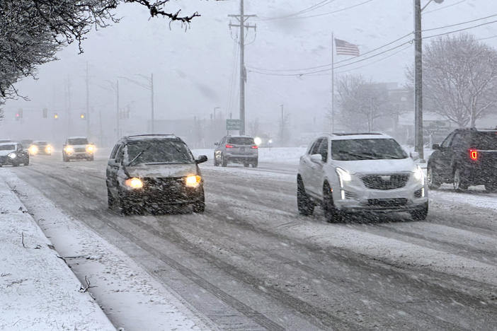 Early rush hour traffic is seen along Orchard Lake Road in West Bloomfield, Mich., shortly after the start of a winter storm Friday.