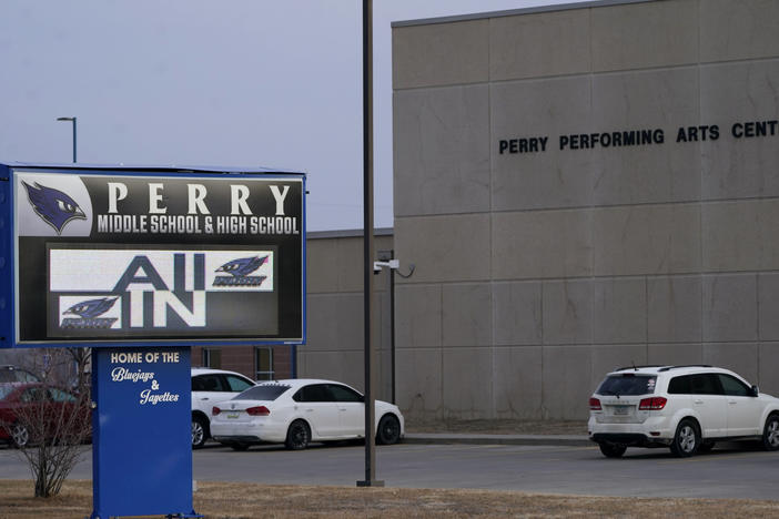 Vehicles are seen in a parking lot outside of Perry High School in Iowa the day after a shooting on Jan. 4, 2024. Dan Marburger, the school's principal who put himself in harm's way to protect students during the shooting, died Sunday, Jan. 14, 2024, a funeral home confirmed after Marburger's after the family announced it on a GoFundMe page.
