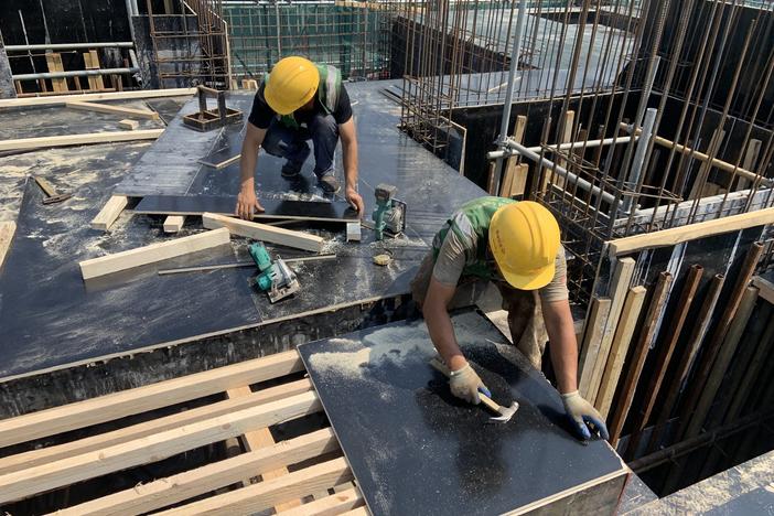 Construction workers build a housing compound in Beijing.