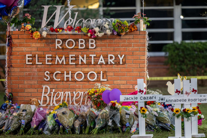 A memorial is seen surrounding the Robb Elementary School sign following the mass shooting at Robb Elementary School on May 26, 2022 in Uvalde, Texas.