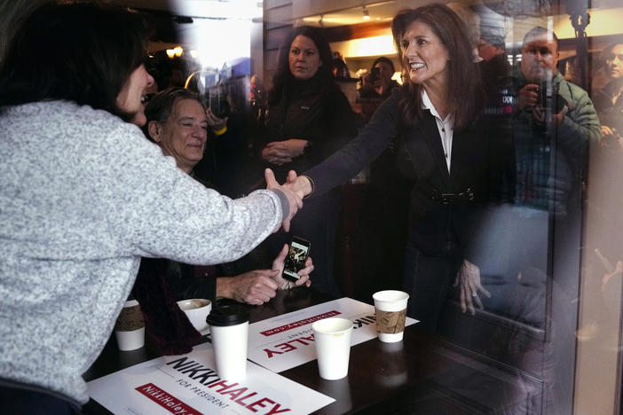 Republican presidential candidate former UN Ambassador Nikki Haley, seen through a storefront window, shakes hands with guests while visiting Kay's Bakery and Cafe, during a campaign stop on Friday in Hampton, N.H.