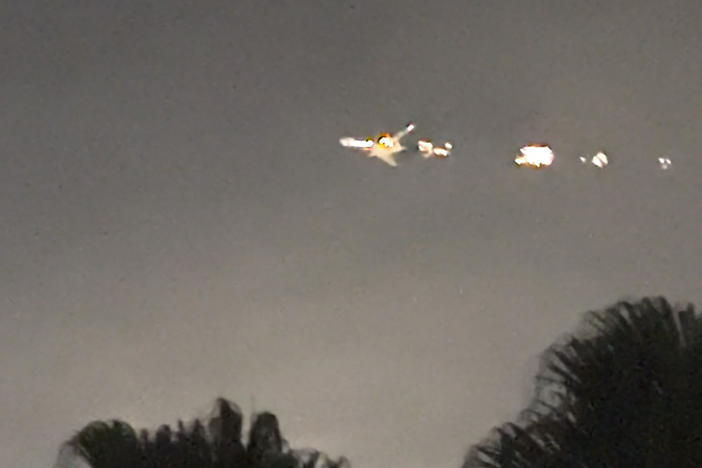 This image taken from video provided by Melanie Adaros shows what she said were sparks shooting from a cargo plane before it made an emergency landing at Miami International Airport on Thursday.