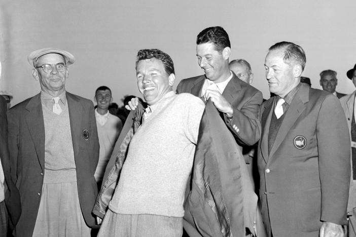 Jack Burke Jr. is helped by Cary Middlecoff as he puts on the traditional coat after winning the 20th Masters Golf Tournament at the Augusta National Golf Course in Augusta, Ga., on April 8, 1956. Burke, the oldest living Masters champion, died Friday in Houston. He was 100.