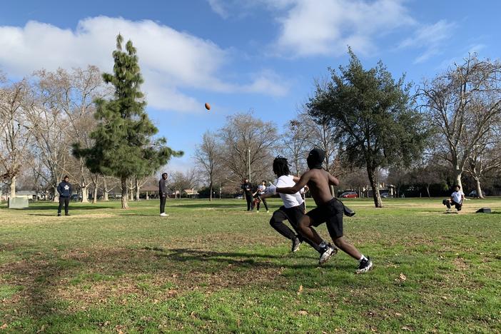 Eleven-year-old Monte Johnson and 9-year-old Waylon Parker run for the ball at a 7-on-7 practice at Tahoe Park in Sacramento, California on Jan. 14, 2023
