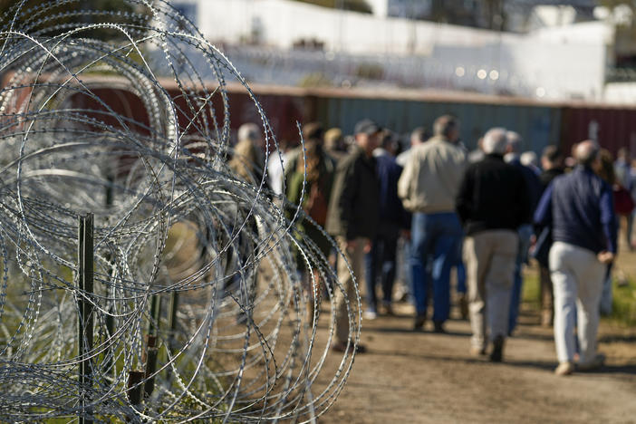 Concertina wire lines the path as members of Congress tour an area near the Texas-Mexico border, Jan. 3, 2024, in Eagle Pass, Texas.