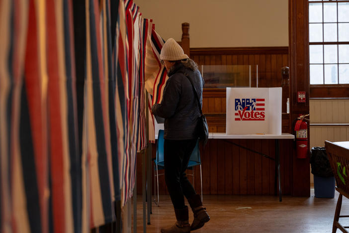 Voter Katie Wilson, 58, walks into a voting booth at the Dublin Town Hall polling place, on Tuesday, Jan. 23, 2024, in Dublin, N.H.