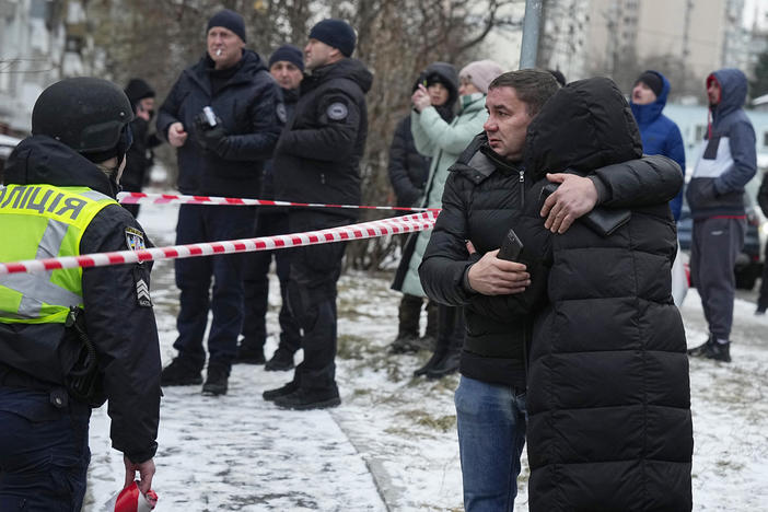 People react at the site of a Russian attack in Kyiv, Ukraine, Tuesday, Jan. 23, 2024.